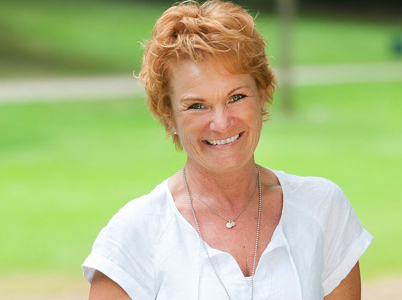 Gisela Goetz, Leiterin der Hauswirtschaft im Kurhaus Hennef, lächelnd im Garten vom Kurhaus