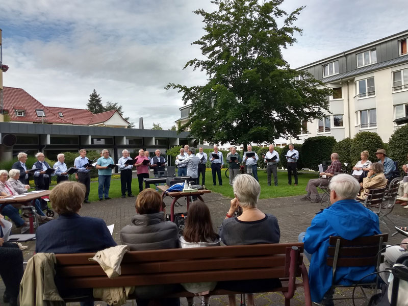 Der Geistinger Männerchor im Kurpark vor der Seniorenresidenz singt für die Bewohner der Pflegebereiches und die Mieter im Betreuten Wohnen.